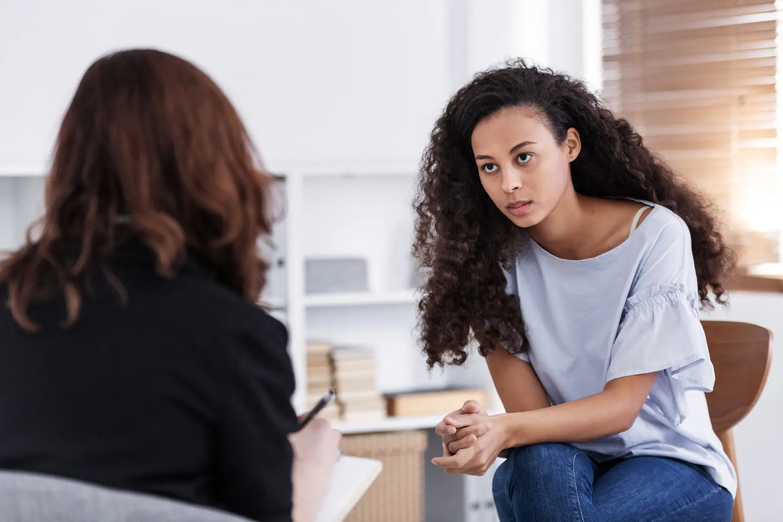 Young woman talking with a therapist about OCD and addiction